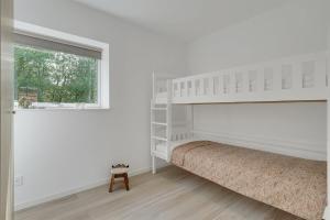 um quarto branco com um beliche e uma janela em GIMLEretreat em Bøtø By
