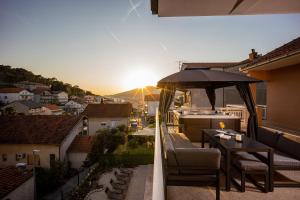 balkon ze stołem, krzesłami i parasolem w obiekcie Beautiful Holiday Home "Villa Relax Oasis" w Trogirze