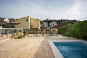 a backyard with a swimming pool and a house at Beautiful Holiday Home "Villa Relax Oasis" in Trogir