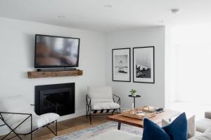 sala de estar con chimenea y TV en la pared en Wellers Landing - Prince Edward County Lakehouse, en Carrying Place