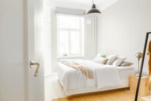 um quarto branco com uma cama e uma janela em Roost Korkea 8 em Helsínquia