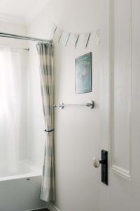 een badkamer met een douchegordijn naast een deur bij Watson House - Century Home near Sandbanks in Cherry Valley