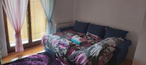 a bed sitting in a room with a window at Sobe Majda in Visoko