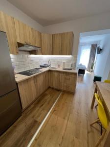 a kitchen with wooden cabinets and a wooden floor at SZWEDZKA22 PL Premium Rooms in Wrocław