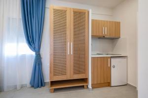a wooden cabinet in a kitchen with a blue curtain at NIRVANA in Platy