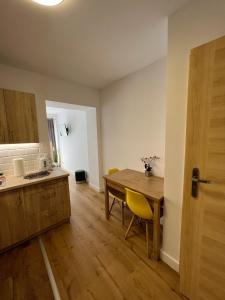 a kitchen with a wooden table and a wooden floor at SZWEDZKA22 PL Premium Rooms in Wrocław