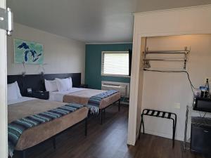 um quarto de hotel com duas camas e uma janela em The Cedar Motel em Sandusky