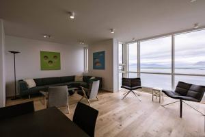 een woonkamer met een bank en stoelen bij Luxury apartment downtown Reykjavik with stunning views in Reykjavík