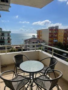 een tafel en stoelen op een balkon met uitzicht op de oceaan bij Family Seaview Ap. Korabi 304 in Durrës