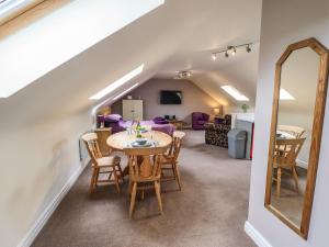 a dining room and living room with a table and a mirror at Barn Owl Annex in Market Rasen