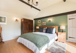 a bedroom with a large bed and a green wall at Woodpecker View in Kirby Misperton