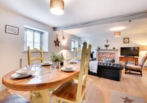 a dining room and living room with a wooden table at Woodpecker Cottage in Pateley Bridge