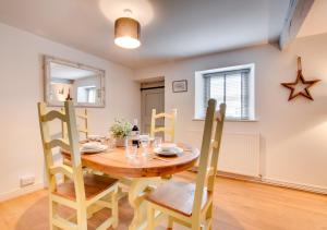 a dining room with a wooden table and chairs at Woodpecker Cottage in Pateley Bridge