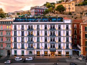 Biały budynek z samochodami zaparkowanymi przed nim w obiekcie Grand Hotel Parker's w mieście Napoli