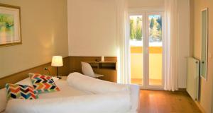 a living room with a white couch and a sliding glass door at Park Hotel Sancelso in Bellamonte