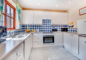- une cuisine avec des placards blancs et du carrelage bleu et blanc dans l'établissement 8 Abrahams Quay, à Whitby
