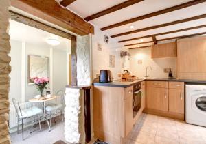 a kitchen with a sink and a dishwasher at Woodpecker Cottage in Hutton le Hole