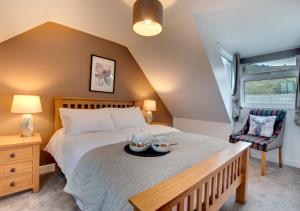 Un dormitorio con una cama con una bandeja de comida. en Woodhead Farm Cottage, en Danby