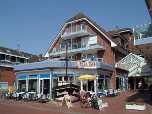 a building with tables and chairs in front of it at Seemeile in Büsum