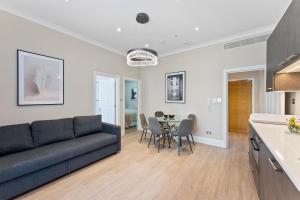 ein Wohnzimmer mit einem Sofa und einem Tisch in der Unterkunft Cleveland Residences Paddington in London