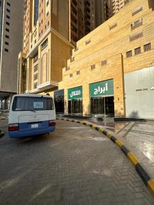 una furgoneta blanca estacionada frente a un edificio en مكة ابراج التلال en Makkah
