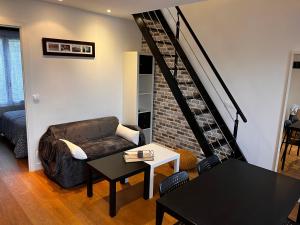 ein Wohnzimmer mit einem Sofa und einem Tisch in der Unterkunft Appartement Saint Germain en Laye in Saint-Germain-en-Laye