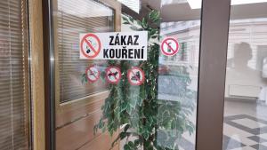 un cartel en una puerta de cristal con una planta en Hotel Rada en Ostrava