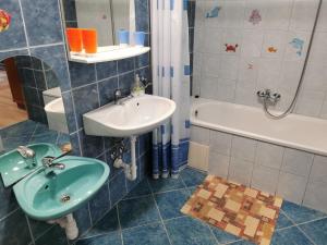 a bathroom with a sink and a bath tub at Glázer Szállás in Tapolca