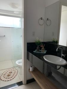 a bathroom with a sink and a toilet at Mirante de Escarpas - 1702 in Capitólio