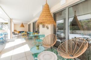 un patio avec des chaises et des tables ainsi qu'une salle à manger dans l'établissement Appart'City Confort La Ciotat - Côté Port, à La Ciotat