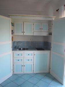 a kitchen with white cabinets and a sink at Aiano Bed&Breakfast in Capri