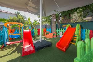 a playground with colorful play equipment and an umbrella at Club Viva Hotel in Marmaris