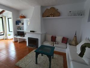 a living room with a white couch and a fireplace at wonderful sunsets views from terraces Last minute in Cala Vadella