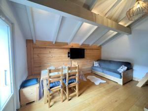 ein Wohnzimmer mit einem blauen Sofa und einem TV in der Unterkunft Appartement Samoëns, 2 pièces, 6 personnes - FR-1-624-98 in Samoëns