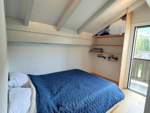 Un dormitorio con una cama azul y una ventana en Appartement Samoëns, 2 pièces, 6 personnes - FR-1-624-98 en Samoëns