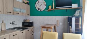 una cocina con fregadero y un reloj en la pared en ARKI, KUĆA ZA ODMOR en Karanac