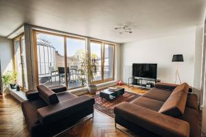 salon z kanapą i telewizorem w obiekcie Constantine Apartments w Rydze