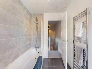 a bathroom with a tub and a walk in shower at It's Broadway Baby! Great house close to City Centre in Belfast
