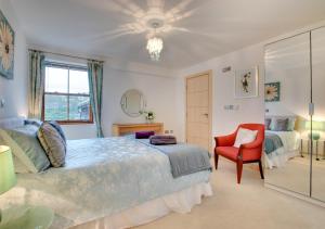 1 dormitorio con 1 cama grande y 1 silla roja en Harbour View Looe, en Looe