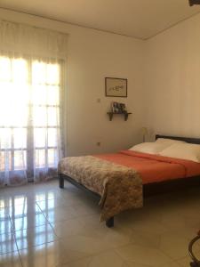 a bedroom with a bed and a large window at LITHOS Porto Kagio in Pórto Káyio