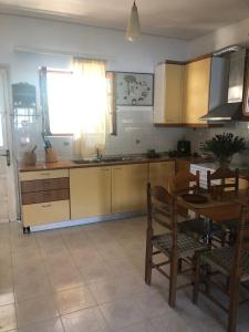 a kitchen with a table and a dining room at LITHOS Porto Kagio in Pórto Káyio