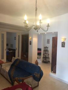 ein Wohnzimmer mit einem blauen Sofa und einem Kronleuchter in der Unterkunft LITHOS Porto Kagio in Porto Kagio