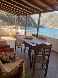 a table and chairs with a view of the ocean at LITHOS Porto Kagio in Pórto Káyio