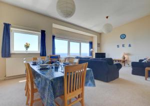 a living room with a table and a blue couch at High Tides in Crafthole