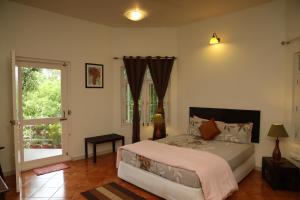 a bedroom with a large bed and a window at Copperhill- A Luxury Homestay in Madikeri