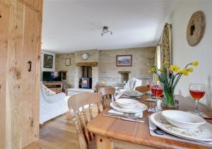 een eetkamer met een houten tafel met wijnglazen bij Westlands Cottage in Mickleby