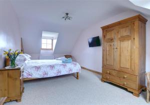 een slaapkamer met een bed en een houten kast bij Westlands Cottage in Mickleby