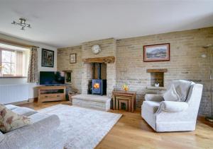 een woonkamer met een bank en een open haard bij Westlands Cottage in Mickleby