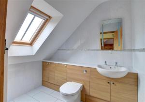 een witte badkamer met een wastafel en een toilet bij Westlands Cottage in Mickleby +8 foto's