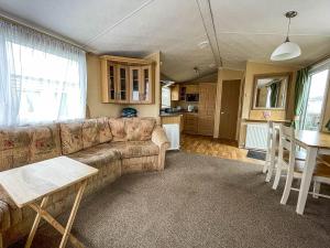 een woonkamer met een bank en een tafel bij Great 6 Berth Caravan With Decking By The Beach In Suffolk Ref 40023nd in Lowestoft